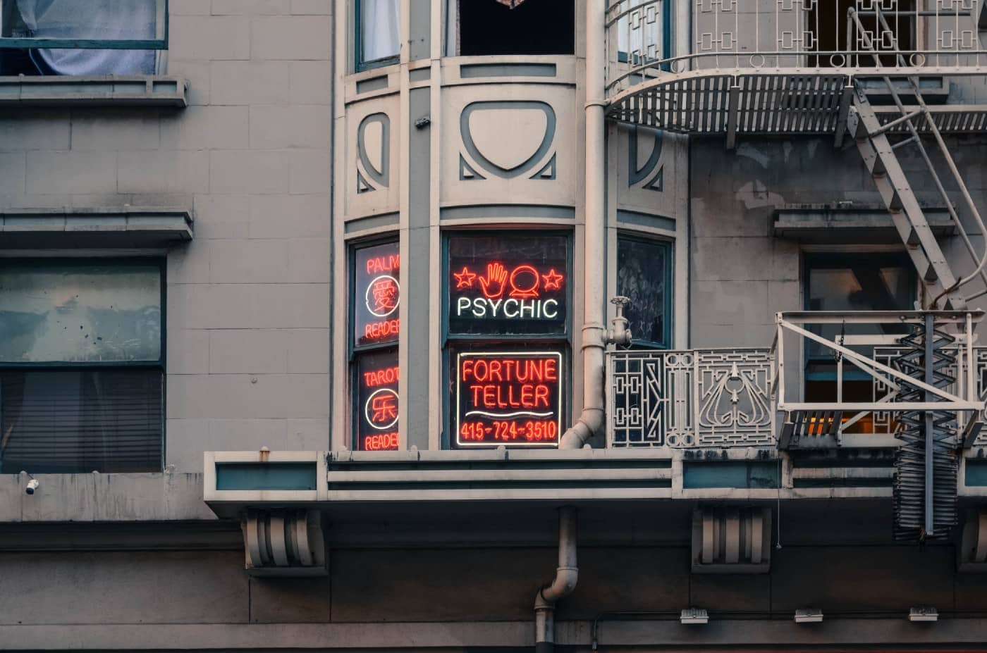 the side of a building with neon signs advertising a “psychic”